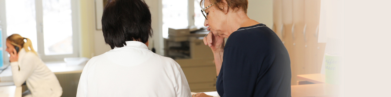 Patientin mit der Mitarbeiterin im Gespräch während des Eintritts in der Rehaklinik Seewis